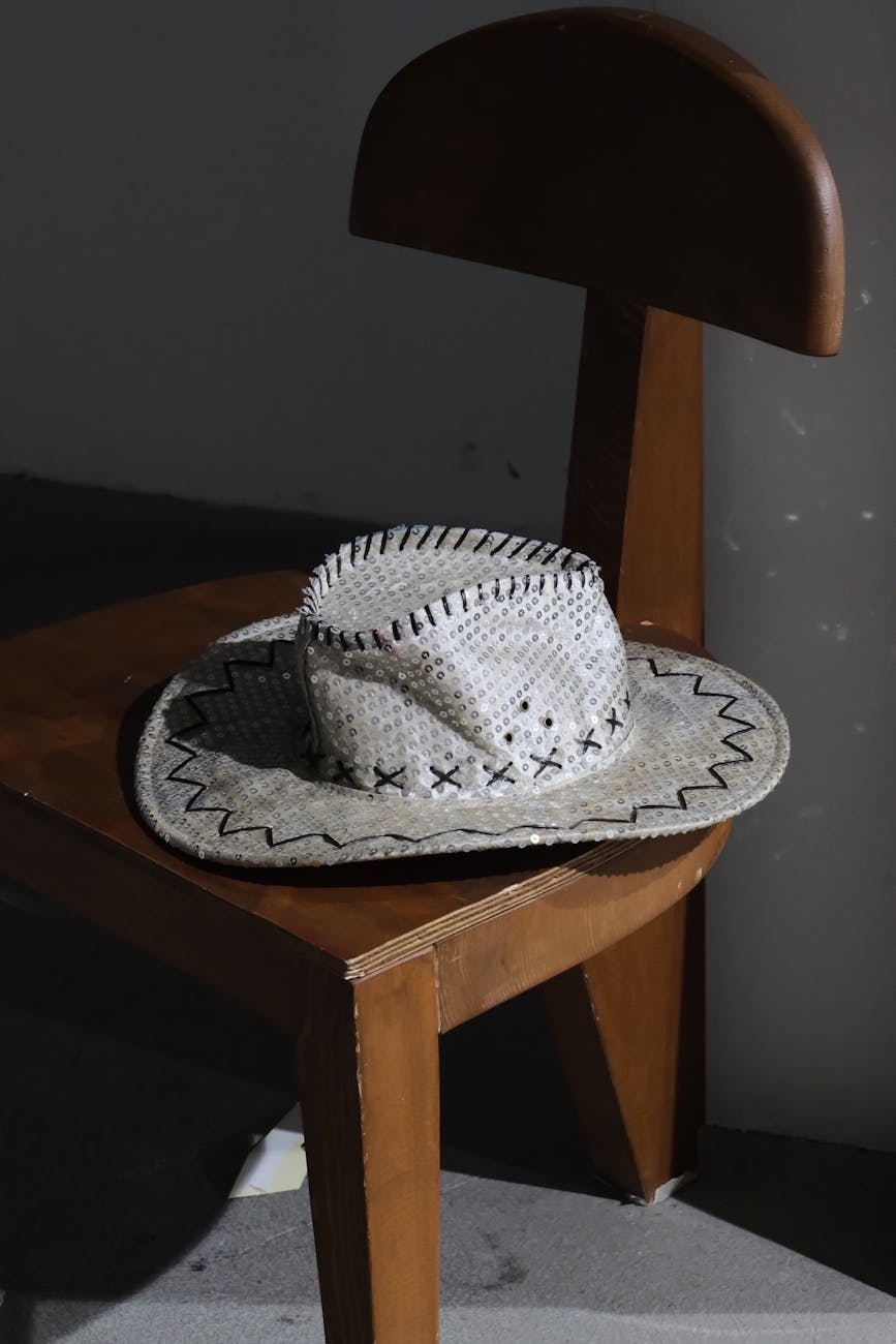 straw cowboy hat on wooden chair in shadow